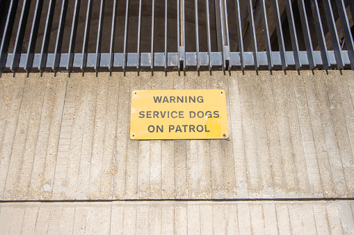 Service Dogs on Patrol Warning Sign on Kensington Road in Kensington, London