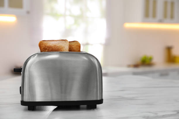 tostadora moderna con rebanadas de pan en la mesa de la cocina. espacio para texto - tostadora fotografías e imágenes de stock