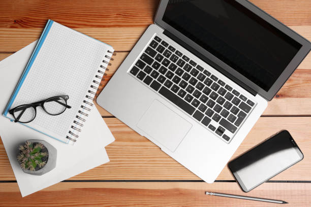 istock Flat lay composition with modern laptop and stationery on office table 1387860075