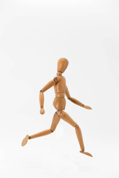 istock wooden doll in running position 1387862734