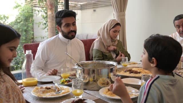 Multi-generation Saudi family enjoying midday meal