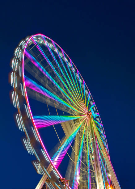 grande roue sur une fête foraine - ferris wheel wheel blurred motion amusement park photos et images de collection