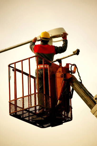 istock Technician works in a bucket high up on a street lights pole 1387864891