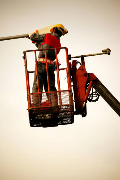 istock Technician works in a bucket high up on a street lights pole 1387864976