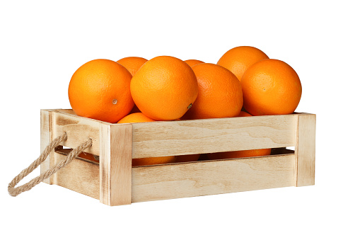 Wooden box with rope handles full of fresh oranges isolated on white