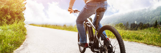 man riding electric mountain bike - electric bicycle imagens e fotografias de stock