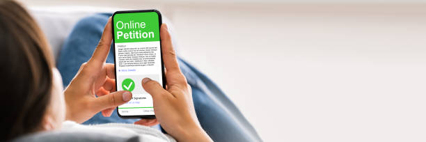 istock Holding Mobile Phone To Sign Petition 1387867148
