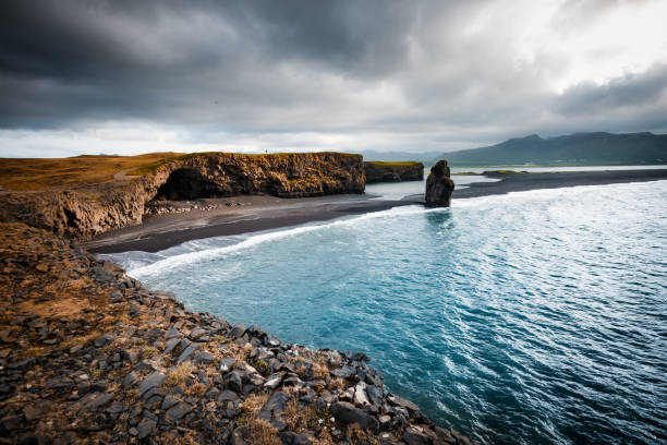 The peaceful seafront of Kirkjufjara beach and Arnardrangur cliff. Location Atlantic ocean near Vik village, Iceland, Europe. Scenic image of beautiful nature landscape. Discover the beauty of earth.