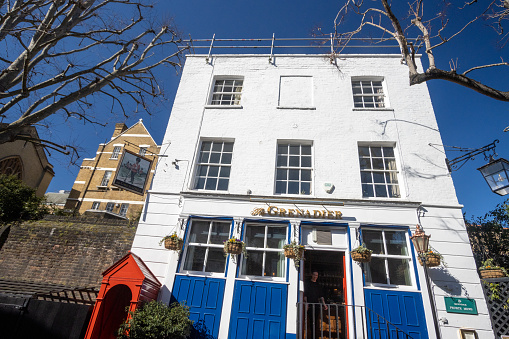 People visible in the doorway of this haunted building - one of the most haunted pubs in London and the UK - was built in 1720 to house the Foot Guards Regiment but was known as Duke of Wellington's Officers' Mess and was visited by King George IV. It was renamed The Guardsman Public House in 1818 after the Grenadier Guards' role in the Battle of Waterloo. It was here that a young grenadier (or subaltern, called Cedric by locals) was caught cheating at cards and beaten to death by his fellow soldiers. The exact date of the event isn't known but thought likely in September as this is when the ghost usually appears. The inside ceiling is covered in notes from all over the world as customers try to pay off Cedric's debts. Famous visitors in recent times include Madonna, Guy Ritchie, Ali G and many from the royal set such as Prince William.