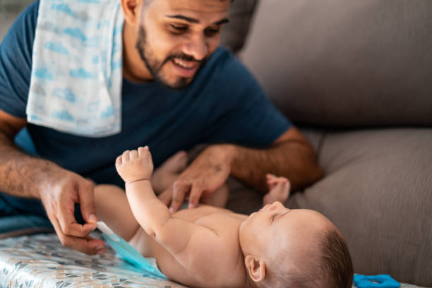 Father changing baby's diaper stock photo