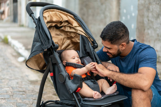 Father playing with baby in stroller
