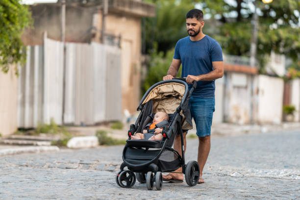 istock Father walking with baby in stroller 1387868790
