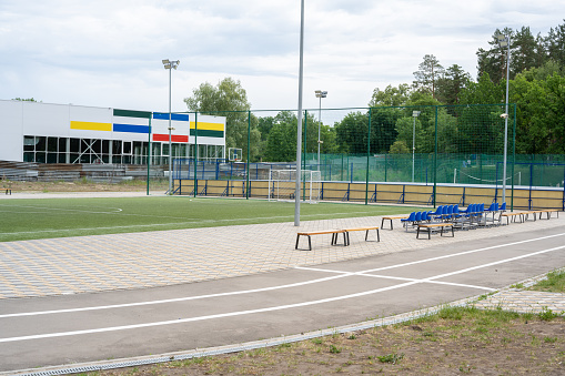 Tolyatti, Russia - July 25 2021: Green soccer field with blue seats. Sports stadium.
