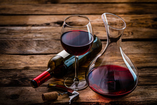 Wineglass wine bottle and decanter on rustic wooden table. Copy space stock photo