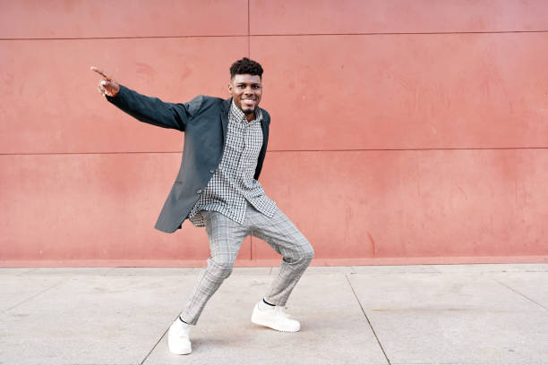 istock african-american man dancing outdoors in casual clothes 1387877565