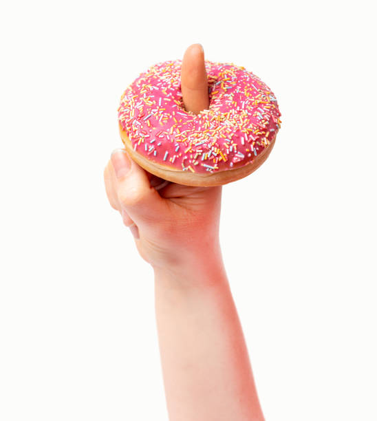 istock holding a pink donut with a finger 1387879374