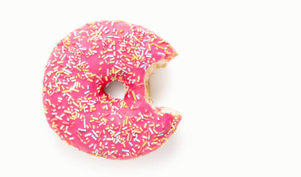 istock pink donut with sugar sprinkles with a bite 1387879392