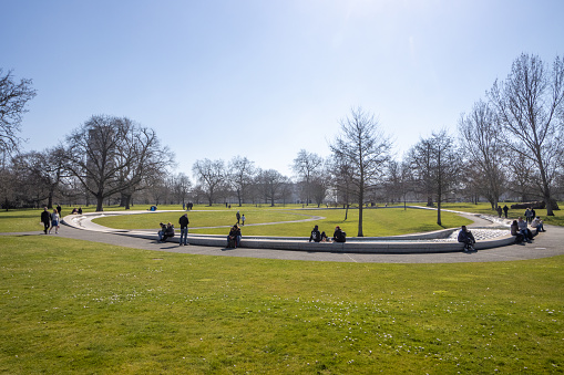 People enjoying the sun around the Princess Diana Memorial Fountain at Hyde Park in City of Westminster, London