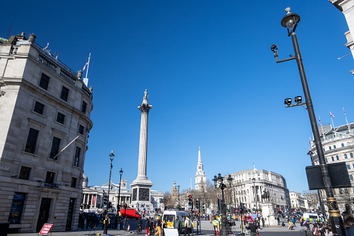 Trafalgar Square, dominated by Nelson's Column  in City of Westminster, London, with many people visible.