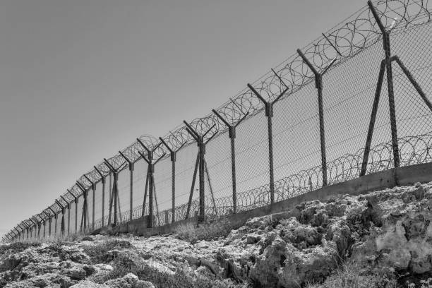istock Military base with barbed wire fence. 1387881448