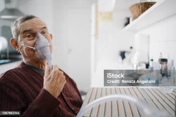 Senior Man Doing Inhalation With Nurse At Home Stock Photo - Download Image Now - Adult, Lung, Mature Adult