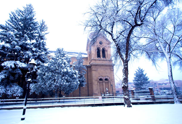 Santa Fe, NM: Saint Francis Cathedral in the snow, side view. The Cathedral Basilica of St Francis of Assisi, a block from the historic Santa Fe Plaza in New Mexico, was built by Archbishop Lamy between 1869 and 1886 in the Romanesque Revival style.