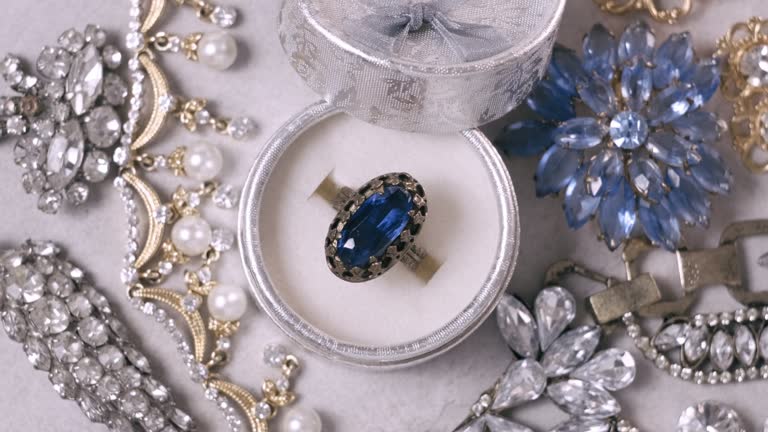 Beautiful golden ring with blue sapphire precious stone. Vintage jewelry on white background. Jewel rotating, closeup, close up, macro, studio shot