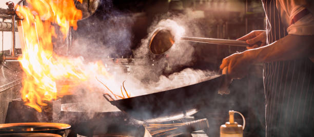 istock Chef stir fry busy cooking in kitchen. 1387907884