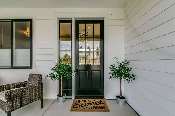 istock White siding surrounding black front door 1387917526