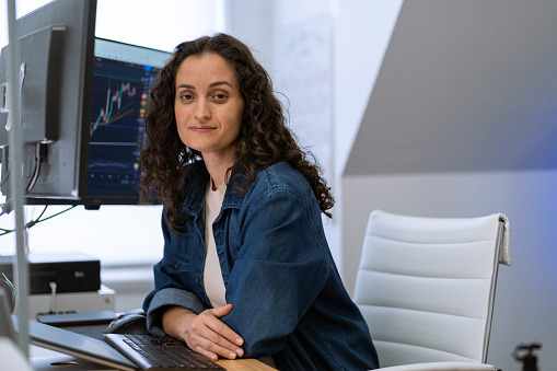 Confident woman working with stock market and cryptocurrency at home