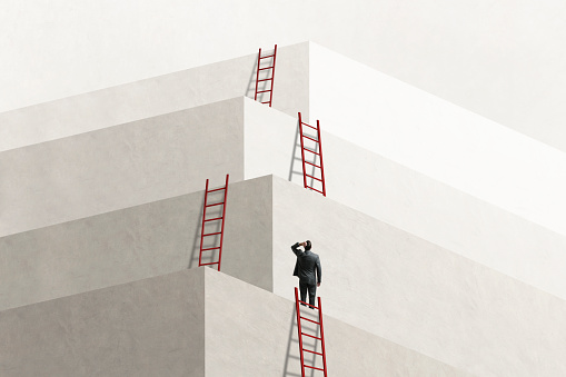 Man Looks Up At Series of Ladders Leading To Successively Higher Levels