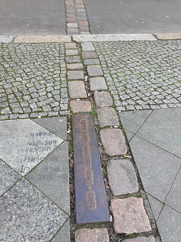 Germany - Berlin - Berlin Wall. Here is a stretch of the famous Berlin Wall, a permit the many remains that can be found throughout the city. On the ground, these plaques show where the wall was and the boundary between East and West Germany.