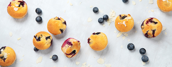 Muffin with blueberries. Fresh berries and sweet pastries on white background, top view.