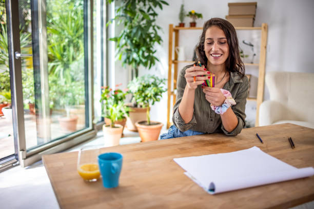 istock Creative young woman drawing at home 1387936108