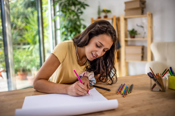 istock Young woman drawing at home 1387936328