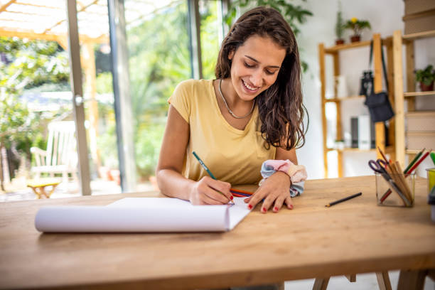 istock Creative young woman drawing at home 1387936440
