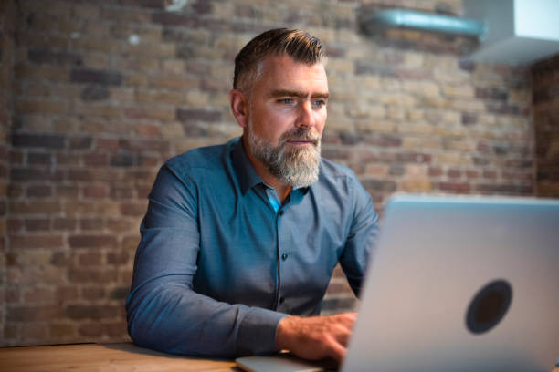 istock Businessman using laptop and drinking coffee 1387936999