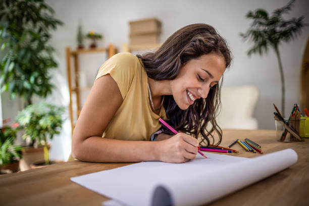 istock Young woman drawing at home 1387937063