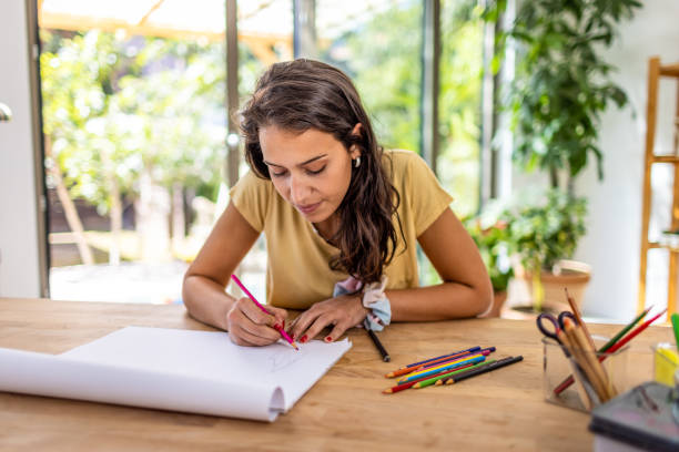 istock Young woman drawing at home 1387937230