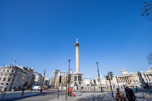 People wealking around Nelson's Column at Trafalgar Square in City of Westminster, London