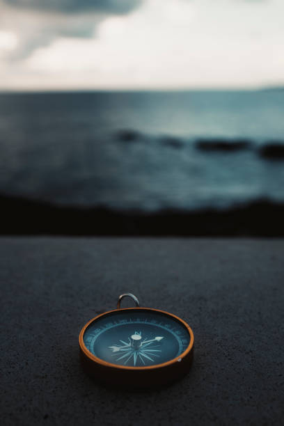 компас путешествия перед водным океаном пейзажа. концепция потерянности и страсти к путешествиям по месту назначения - drawing compass фотографии стоковые фото и изображения