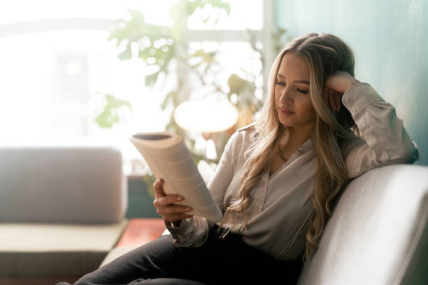 istock Woman reading a book on the sofa 1387950793