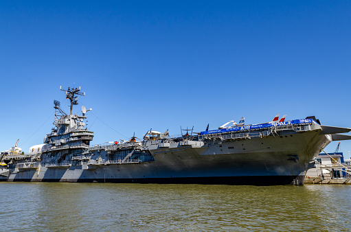 Intrepid Sea-Air-Space Museum at Hudson River side view, New York City during sunny winter day with clear sky, horizontal