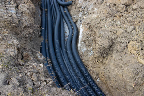 istock Black corrugated plastic drainage pipes laying in a ditch at a construction site 1387953531