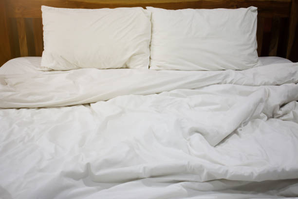 istock Messy white bed and pillow, in the morning 1387954250