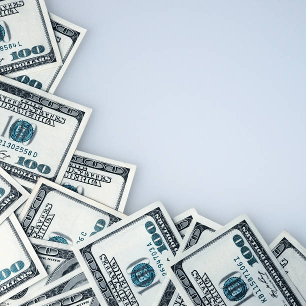 istock Hundred-dollar bills are scattered in a frame on a white background. 1387957577