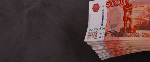 istock Russian rubles a large bundle on a gray background. A bundle of five-thousand-ruble notes. 1387958110