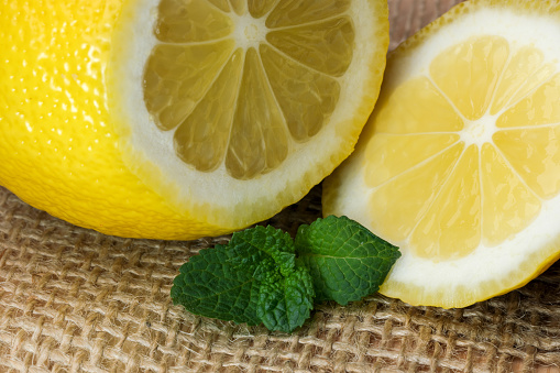 Cut lemon close-up on a table with a napkin next to fragrant mint leaves