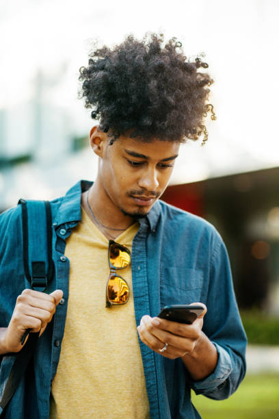istock African American man with braided hair  using smart phone while in downtown 1387960273