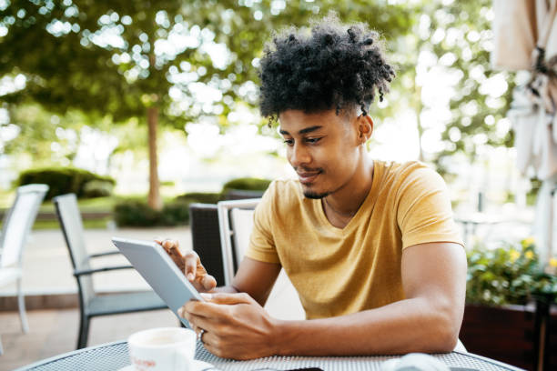 istock African American man with curly hair and braids using digital tablet 1387960278